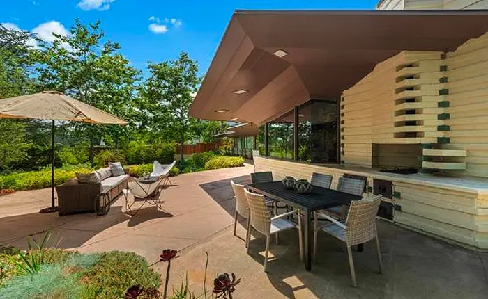 La Canada Flintridge architectural home by Lloyd Wright offers a s diagonally scored concrete patio and an original built-in barbecue