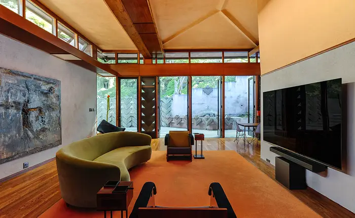 At the heart of the Beverly Johnson House within the David Lynch Hollywood Hills Compound is a striking living room defined by soaring clerestory windows and signature Lloyd Wright concrete blocks.