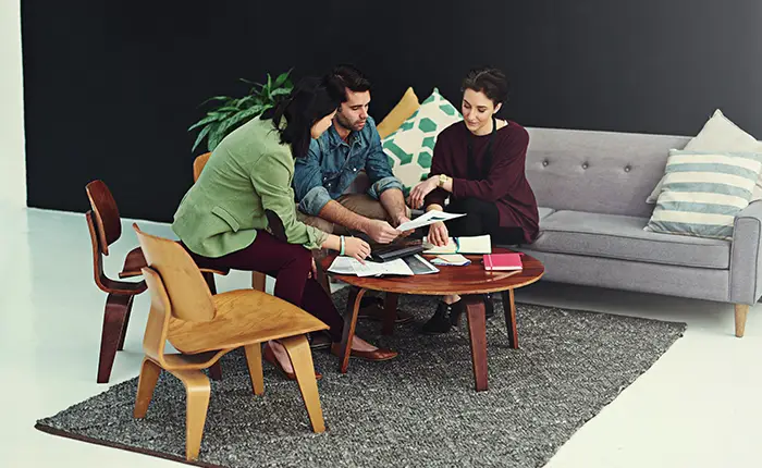 A group sitting around Ray Eames furniture